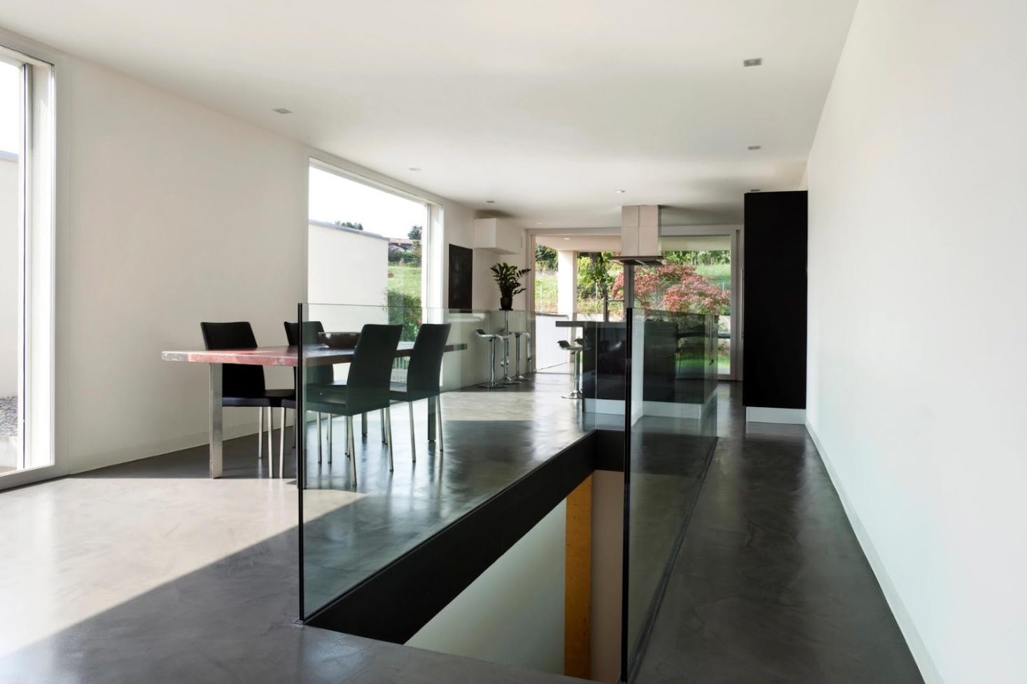 Modern kitchen with glass railings around basement entrance stairs.